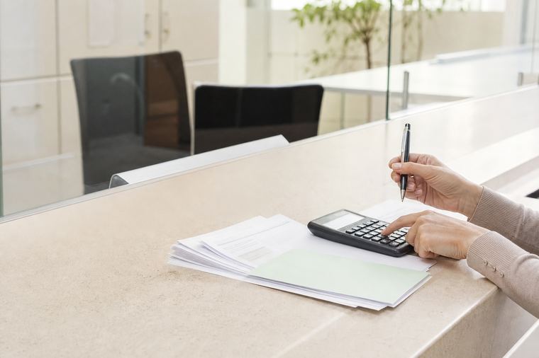 Una scrivania d'ufficio con due schermi accesi, in un ambiente di lavoro ordinato.